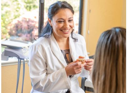 Photo of a female staff member laughing with a male patient.